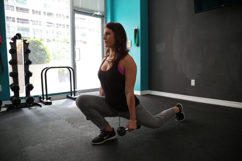 woman doing dumbbell split squats